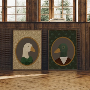 May include: Two framed illustrations of a goose and a duck wearing formal attire. The goose is wearing a green bow tie and the duck is wearing a brown vest and a monocle. The frames are brown and have a white background with a green clover pattern.