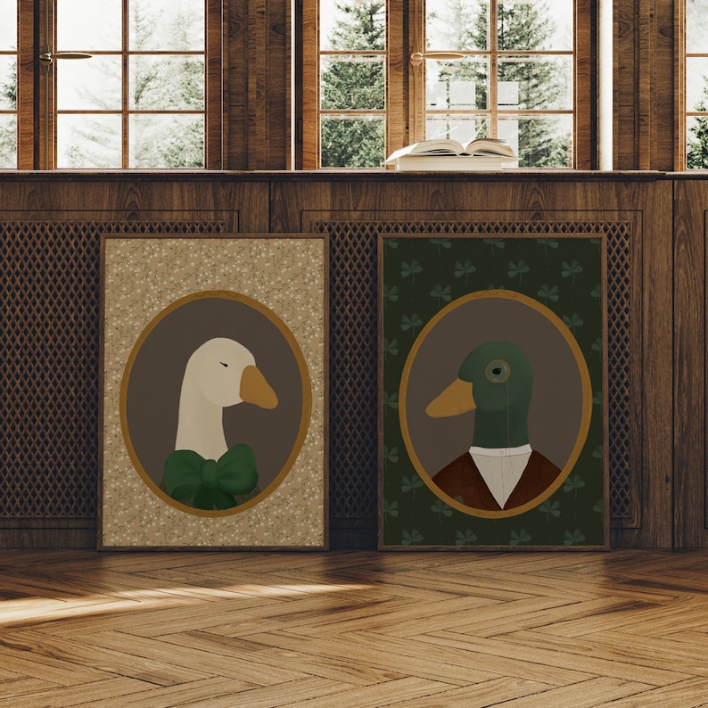 May include: Two framed illustrations of a goose and a duck wearing formal attire. The goose is wearing a green bow tie and the duck is wearing a brown vest and a monocle. The frames are brown and have a white background with a green clover pattern.