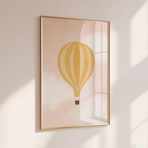 May include: A framed print of a yellow and white striped hot air balloon against a pink and white cloudy background.