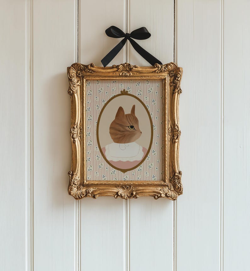 Pode incluir: Uma impress&atilde;o emoldurada de um gato usando um colar rosa e uma camisa branca, com um fundo de padr&atilde;o floral.