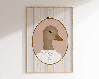May include: A framed illustration of a brown goose wearing a white lace collar with a blue bow. The goose is in an oval frame with a pink background. The frame is on a striped background with a floral pattern.