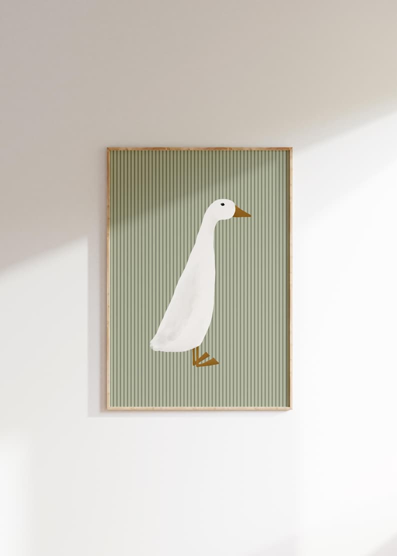 May include: A framed print of a white duck with brown feet and beak, standing on a green striped background.