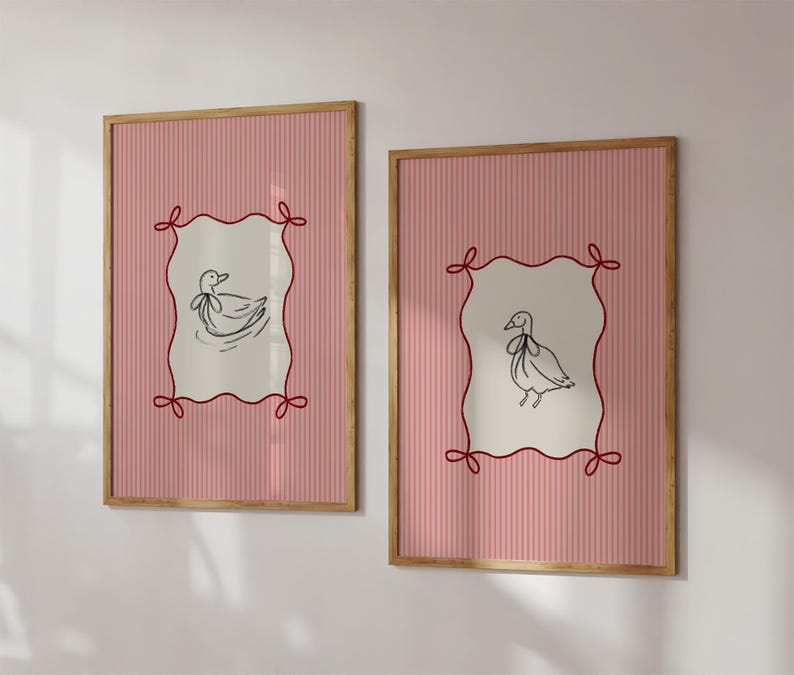 May include: Two framed prints with pink and white striped backgrounds. Each print features a black and white illustration of a duck inside a red, white, and black frame.