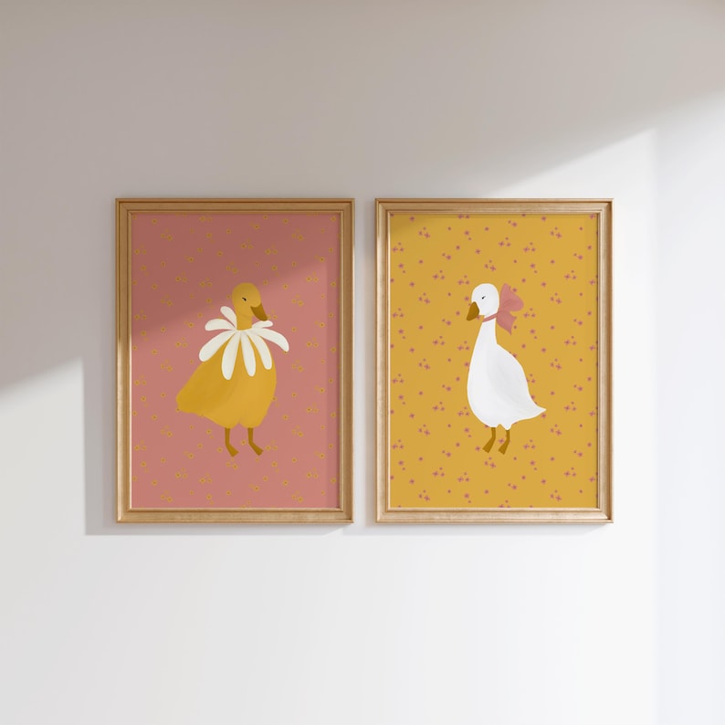 Pu&ograve; includere: Due stampe incorniciate con illustrazioni di oche. La stampa a sinistra presenta un'oca gialla con un collare di fiori bianchi su uno sfondo rosa con un motivo a pois bianchi. La stampa a destra presenta un'oca bianca con un fiocco rosa su uno sfondo giallo con un motivo a pois rosa.