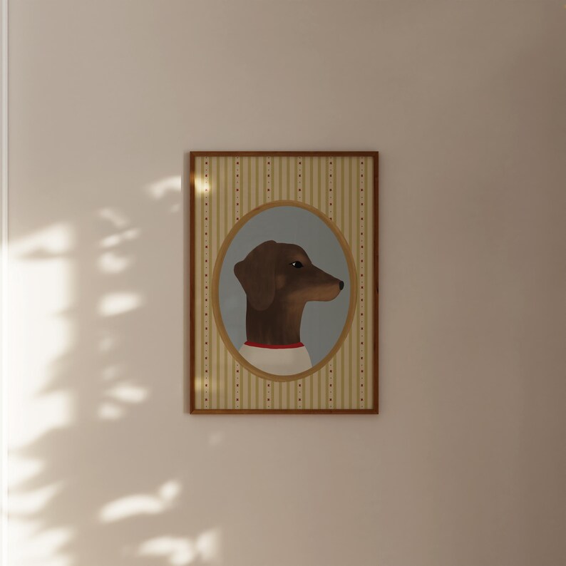 May include: A framed portrait of a dachshund dog in profile. The dog is brown with a red collar and a white shirt, set against a light blue oval. The background features vertical stripes in beige and white, framed in a wooden border.