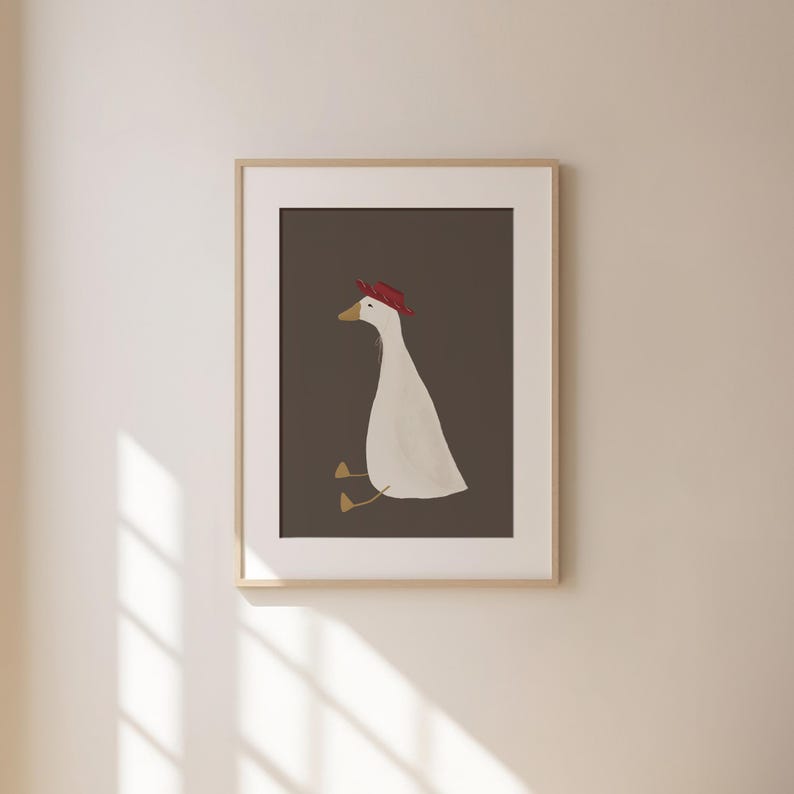 May include: A framed illustration of a white goose wearing a red hat, sitting on a brown background.