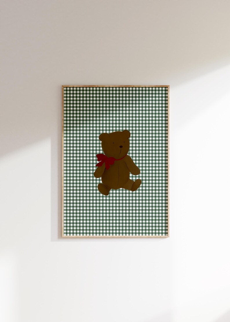 May include: A framed print of a brown teddy bear with a red bow, sitting on a green and white gingham background.