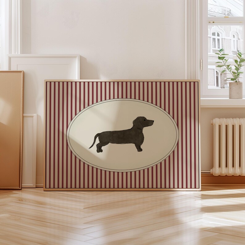 May include: A framed artwork featuring a dachshund illustration. The dog is depicted in a dark color within an oval frame, set against a background of vertical red and white stripes. The artwork is encased in a wooden frame.