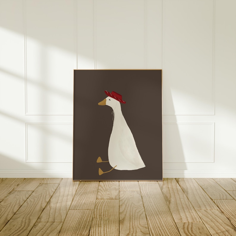 May include: A white goose wearing a red hat sits on a dark brown background. The goose is facing to the left and has its head tilted slightly to the right. The goose's feet are visible and are a light brown color.