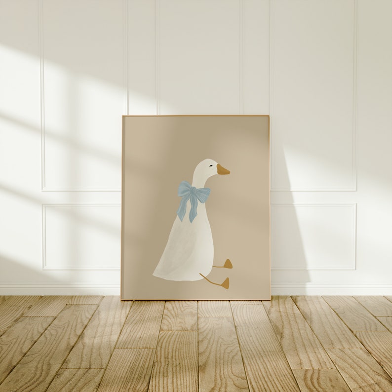 May include: A white goose with a blue bow sits on a beige background. The goose is facing to the right and has a yellow beak.