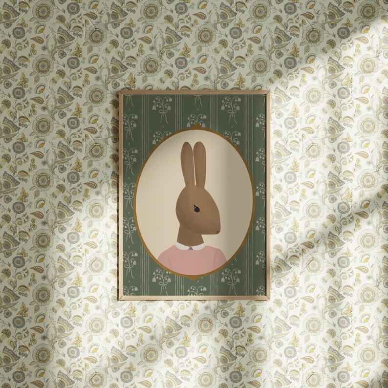 May include: A framed illustration of a brown rabbit wearing a pink shirt. The illustration is set against a green background with a white floral pattern.