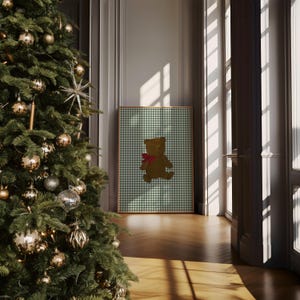 May include: A framed print of a brown teddy bear wearing a red bow on a green and white gingham background.