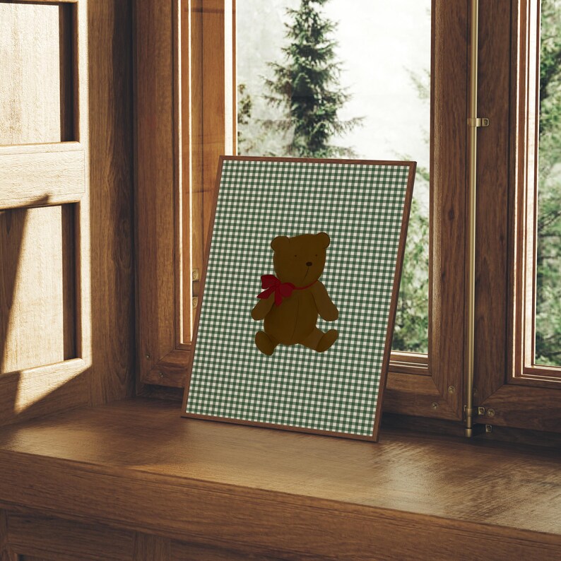 May include: A framed print of a brown teddy bear with a red bow on a green and white gingham background.