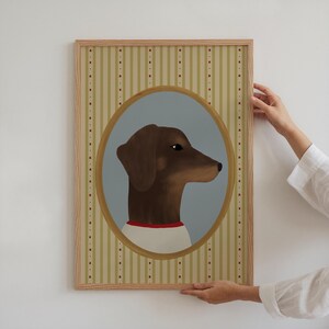 May include: A framed artwork featuring a brown dachshund dog in profile, set within an oval frame against a light blue backdrop. The dog wears a white shirt with a red collar. The frame has a striped background.