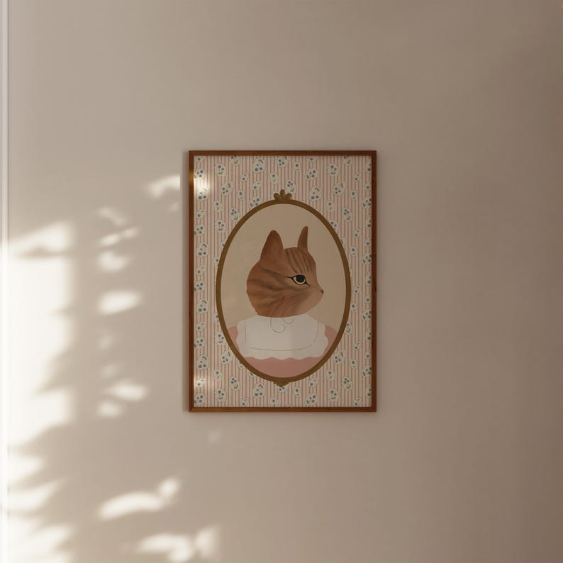 Pode incluir: Uma impress&atilde;o emoldurada de um gato vestindo um vestido rosa e um colar branco. O gato est&aacute; olhando para a direita. A moldura tem um padr&atilde;o floral com flores rosa e azuis sobre um fundo branco.
