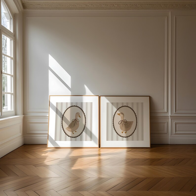 May include: Two framed prints of a brown duck with a brown bow on a white and gray striped background.