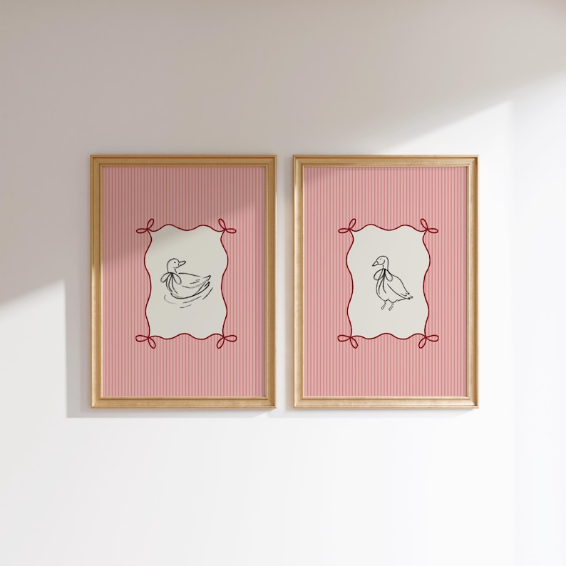May include: Two framed prints with pink and white striped backgrounds. Each print features a black line drawing of a duck with a red ribbon around its neck inside a red, white, and cream colored frame.