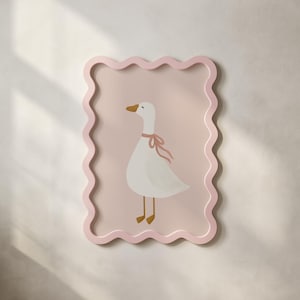 Può includere: Un'opera d'arte incorniciata con un'illustrazione stravagante di un'oca bianca con un nastro rosa intorno al collo. L'oca è ambientata su uno sfondo rosa tenue, incorniciata da un bordo ondulato rosa chiaro. L'opera d'arte ha un'estetica affascinante e infantile.