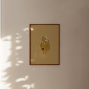 Puede incluir: Una ilustraci&oacute;n enmarcada de un pollito amarillo con un gorro de patr&oacute;n blanco y negro, sosteniendo una taza roja. El pollito est&aacute; de pie sobre un fondo amarillo claro.