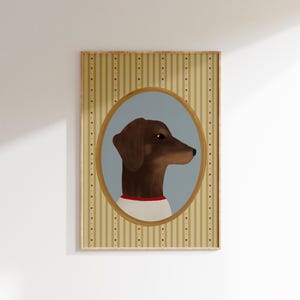 May include: A framed portrait of a brown dachshund dog in profile, set against a light blue oval. The dog wears a white shirt with a red collar. The background is a striped pattern in beige and gold with red dots.