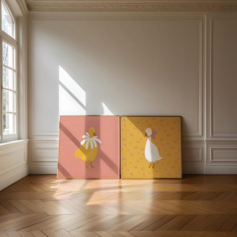 Pu&ograve; includere: Due illustrazioni incorniciate di oche. L'oca a sinistra &egrave; gialla con un fiore bianco sulla testa. L'oca a destra &egrave; bianca con un fiore rosa sulla testa. Entrambe le oche sono in piedi su uno sfondo giallo con fiori rosa.