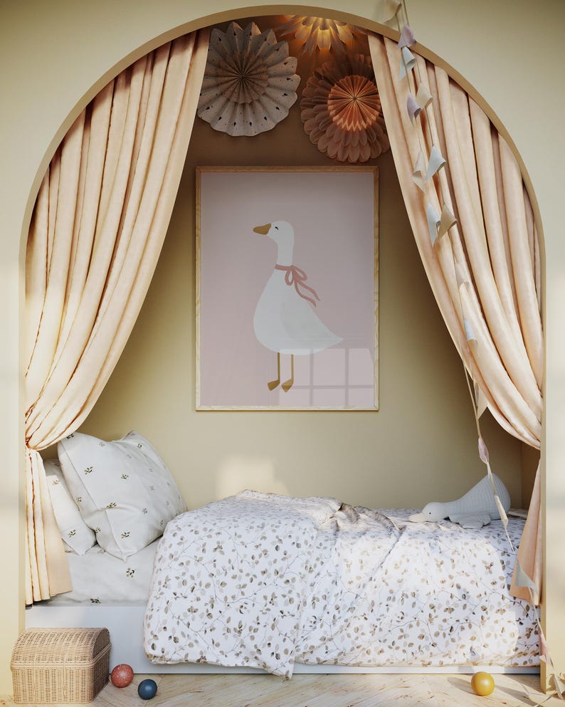 May include: A framed print of a white goose with a pink ribbon around its neck hangs above a bed with a floral patterned comforter and pillows. The bed is in a cozy nook with peach-colored curtains and decorative paper fans.