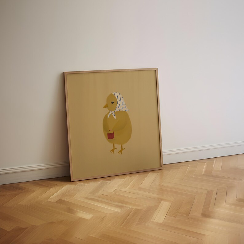 Puede incluir: Una ilustraci&oacute;n enmarcada de un pollito amarillo con un pa&ntilde;uelo de cabeza estampado en azul y blanco y sosteniendo un peque&ntilde;o cubo rojo.