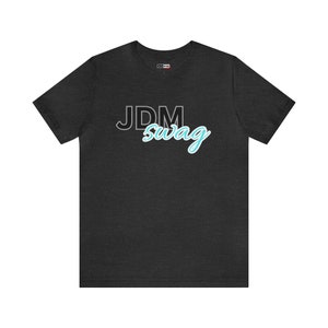 May include: A dark grey t-shirt with the text "JDM swag" printed on the front in black and blue.