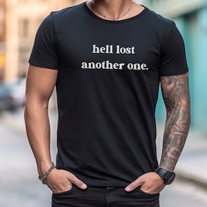 May include: Black t-shirt with white text that reads "hell lost another one."