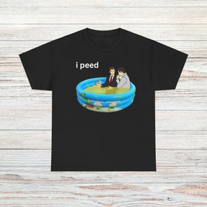 Puede incluir: Una camiseta negra con el texto "i peed" impreso en blanco. La camiseta presenta un gráfico de dos hombres sentados en una pequeña piscina inflable llena de líquido amarillo.