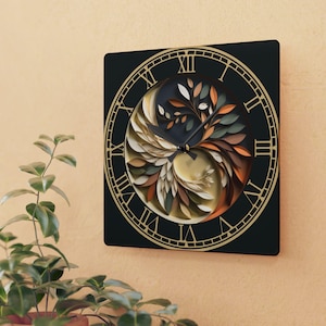 May include: A square wall clock with a black face and gold Roman numerals. The center features a layered, circular design of stylized leaves in shades of cream, sage green, and burnt orange, arranged in a swirling pattern with black clock hands.