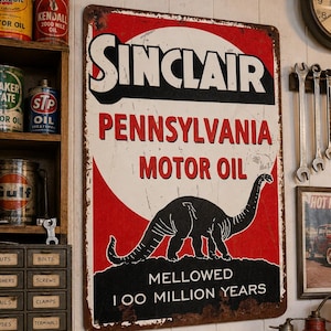 May include: A rectangular metal sign featuring the Sinclair Pennsylvania Motor Oil logo with a black dinosaur silhouette on a red and white background. The text reads Sinclair, Pennsylvania Motor Oil, and Mellowed 100 Million Years, with visible rust along the edges.