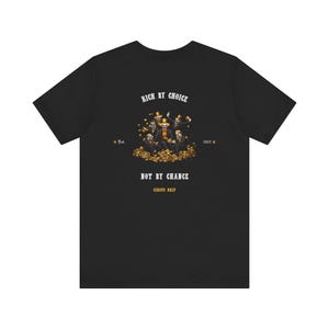 May include: Black t-shirt with a graphic featuring a group of figures in suits and top hats, surrounded by gold coins. The text "RICH BY CHOICE" and "NOT BY CHANCE" are above and below the graphic, with "Circus Drip" at the bottom.