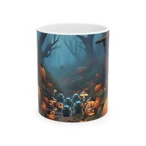 May include: A white ceramic mug featuring a dark, misty forest scene with orange pumpkins, glowing jack-o'-lanterns, and small, fuzzy blue creatures walking along a path. The design includes various mushrooms and tall, dark, leafless trees.