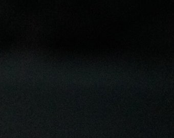 May include: A black fabric surface with a subtle texture.