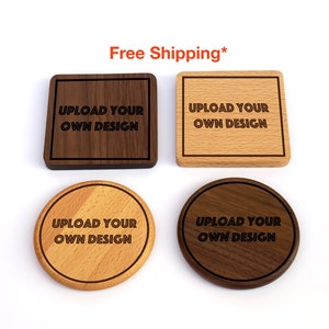 May include: Four wooden coasters in rounded square and round shapes. The coasters are made of light and dark wood. The text "UPLOAD YOUR OWN DESIGN" is engraved on each coaster.