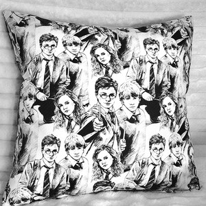 May include: Black and white throw pillow featuring a repeating pattern of illustrated characters with glasses, ties, and wands. The pillow is square and appears to be made of a soft fabric.
