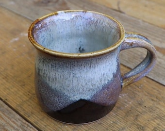 Hand thrown stoneware mugs glazed with white speckled chun glaze over a teadust iron glaze.