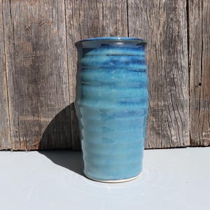 Blue stoneware vase with blue green speckled glaze on buff clay