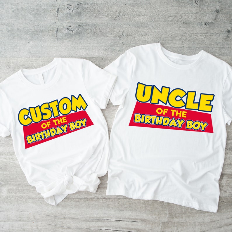 Puede incluir: Dos camisetas blancas con un dise&ntilde;o gr&aacute;fico rojo y amarillo. La camiseta de la izquierda dice "Custom of the Birthday Boy". La camiseta de la derecha dice "Uncle of the Birthday Boy".