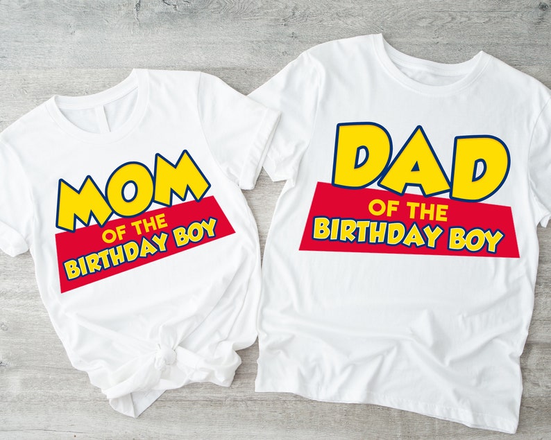 Puede incluir: Dos camisetas blancas con un dise&ntilde;o gr&aacute;fico amarillo y azul. El texto en las camisetas dice "Mom of the Birthday Boy" y "Dad of the Birthday Boy".