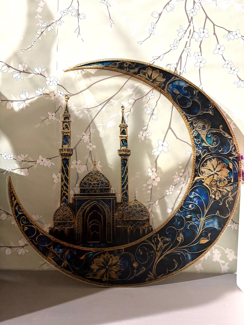 May include: A decorative crescent moon with intricate gold and blue floral designs, featuring a silhouette of a mosque with minarets.