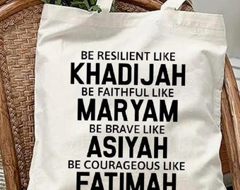 May include: White tote bag with black text that reads "Be resilient like Khadijah, Be faithful like Maryam, Be brave like Asiyah, Be courageous like Fatimah."