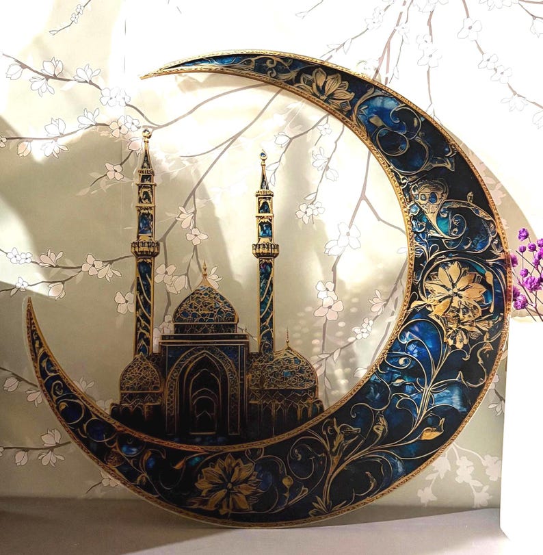 May include: A gold and blue crescent moon wall decor with an intricate floral design. The moon is decorated with a silhouette of a mosque with two minarets.