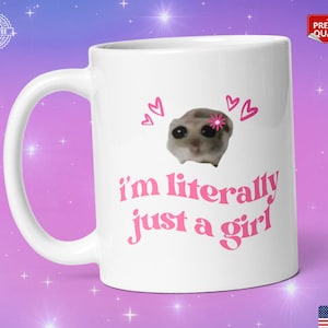 Pu&ograve; includere: Tazza in ceramica bianca con un design rosa. La tazza presenta un'immagine di un piccolo animale con un fiore sulla testa e il testo "i'm literally just a girl".