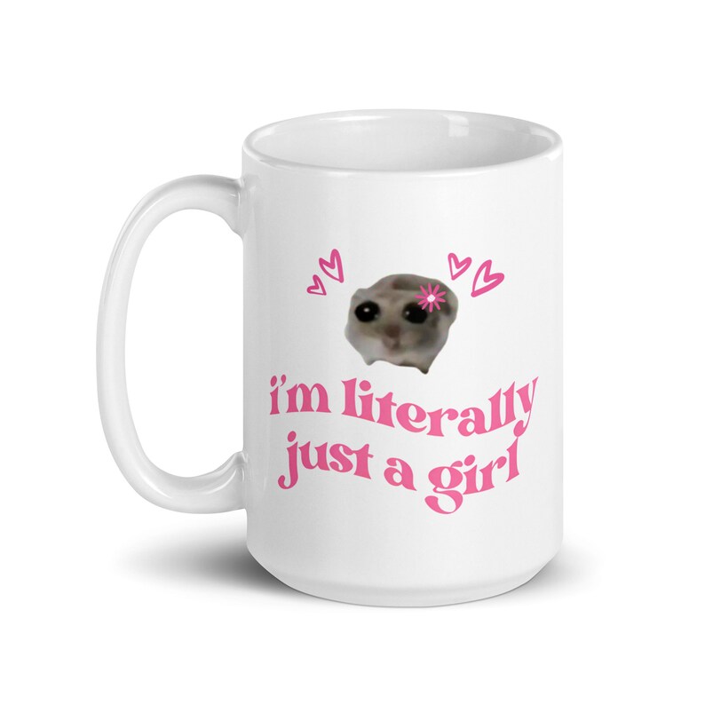 Pu&ograve; includere: Tazza in ceramica bianca con un design rosa. Il design presenta un piccolo animale con un fiore sulla testa, circondato da cuori. Il testo "i'm literally just a girl" &egrave; scritto in rosa sotto l'animale.