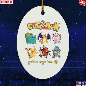 Puede incluir: Adorno ovalado blanco con el texto "CageMon" y personajes de dibujos animados. El adorno presenta una cuerda dorada para colgar y la frase "gotta cage 'em all!"