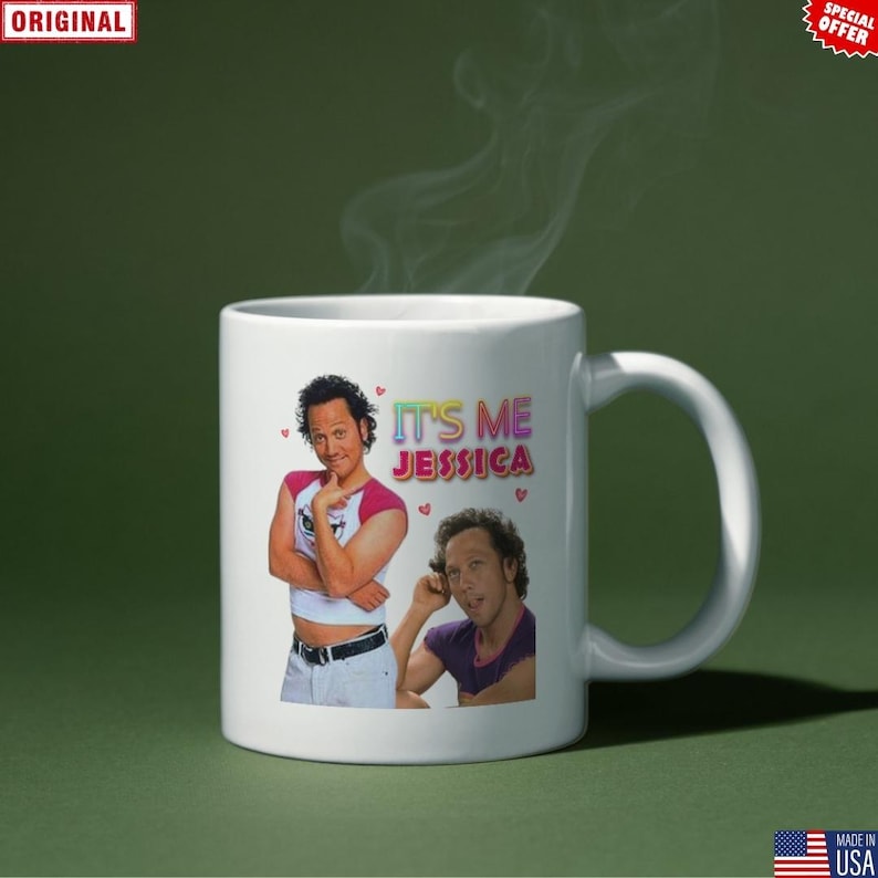 May include: White ceramic mug featuring two images of a man and the text "IT'S ME JESSICA" in colorful letters. The mug has a curved handle and is set against a green background.