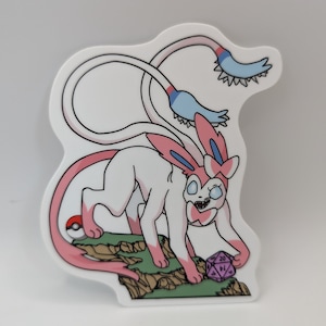 Op de afbeelding: Een roze en blauwe cartoon sticker van een Pokémon-personage, bekend als Gardevoir, met een paarse en witte 20-zijdige dobbelsteen.