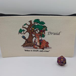 May include: A beige canvas zippered pouch with a printed design of a deer in a forest setting. The pouch has the word "Druid" printed on it and the text "When in doubt, ask a tree".